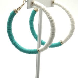 A pair of hoop earrings with turquoise and white beads.