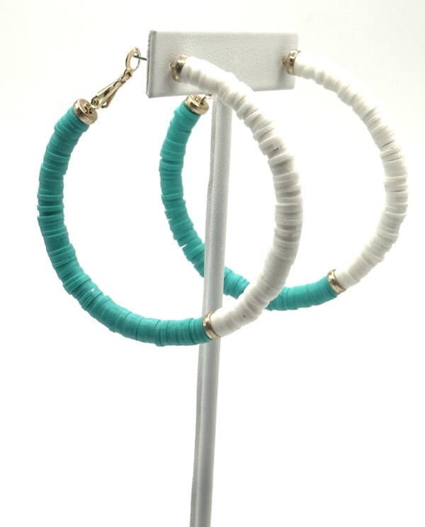 A pair of hoop earrings with turquoise and white beads.