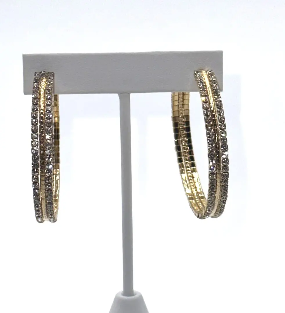 A pair of gold hoop earrings with a white background