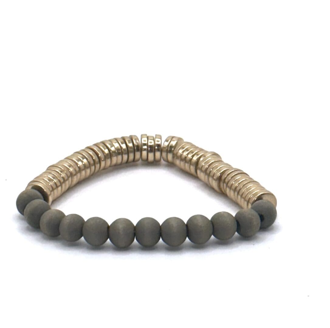 A bracelet with gold and black beads on it.