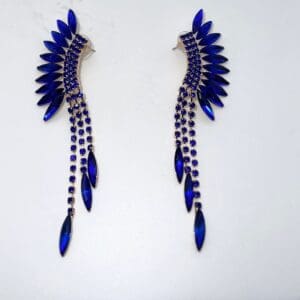 A pair of blue earrings with long chains hanging from them.
