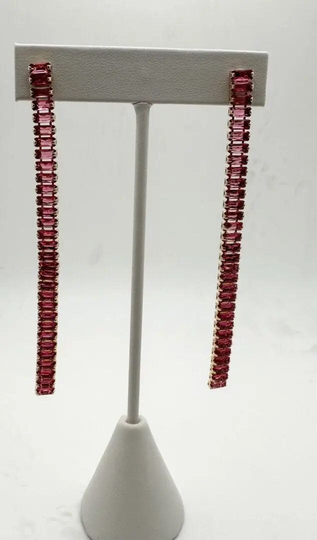 A pair of red earrings hanging from a pole.