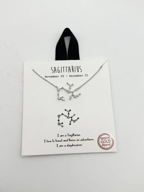 A silver necklace and earring set with the sagittarius symbol.