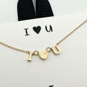 A gold necklace with the letter u and heart.